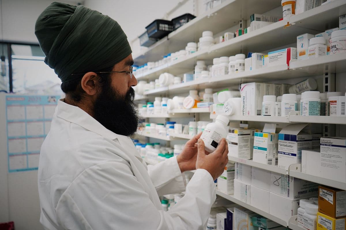A pharmacist checking a compounded medication against the prescription